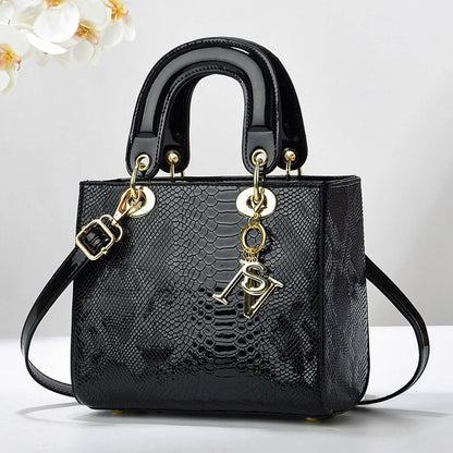 Elegant black textured handbag with gold accents and detachable strap, featuring a sleek design suitable for sophisticated outings.