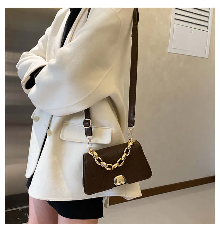 Woman wearing elegant dark brown Crossbody Messenger Bag Purse with chain detail, perfect for stylish on-the-go use.