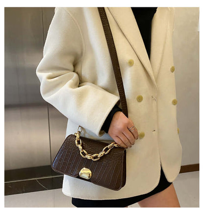 Woman wearing a white coat carrying a dark brown Crossbody Messenger Bag Purse with a gold chain accent.