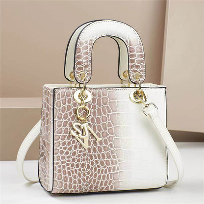 Elegant two-tone handbag with a crocodile pattern design, showcasing golden accents and a chic square shape.