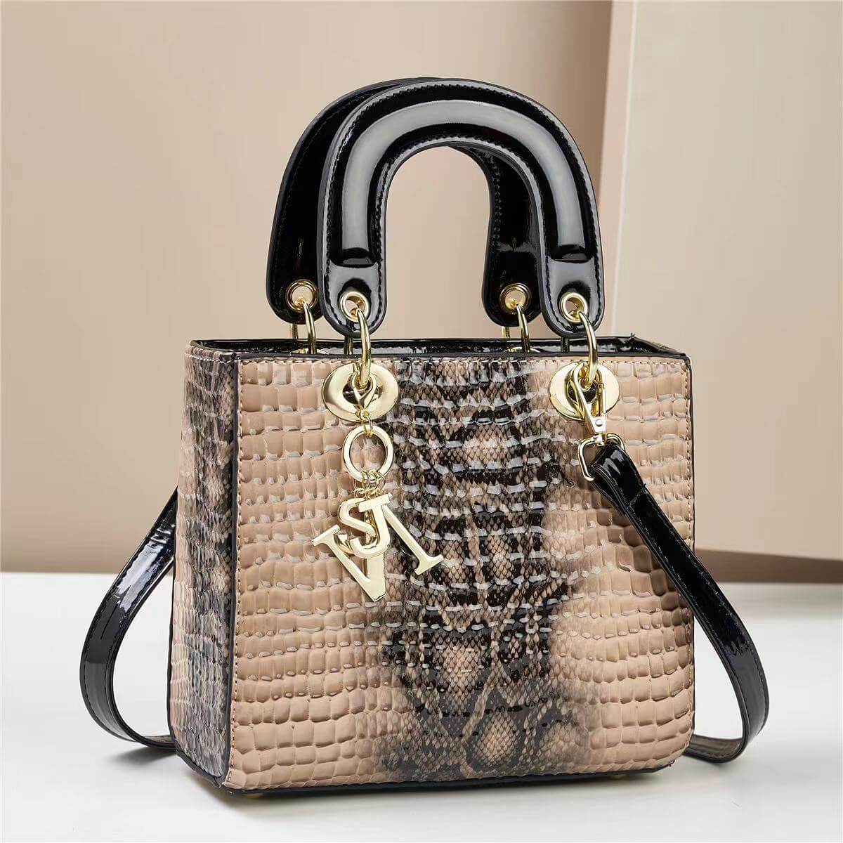 Chic faux snakeskin handbag with black glossy handles, featuring gold accents and adjustable strap, ideal for stylish urban look.