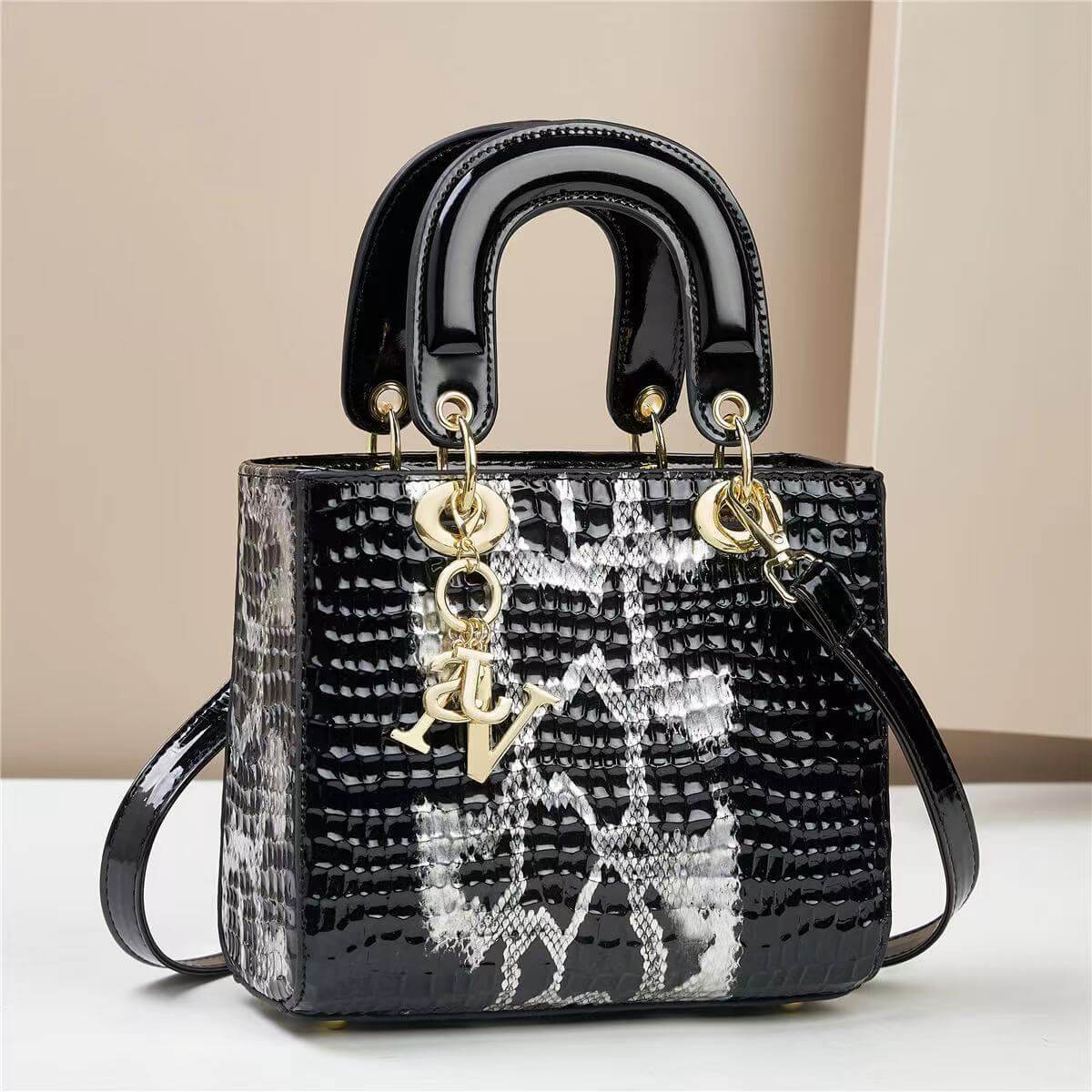 Chic black and white square handbag with embossed texture and gold accents, featuring a sturdy handle for stylish everyday use.