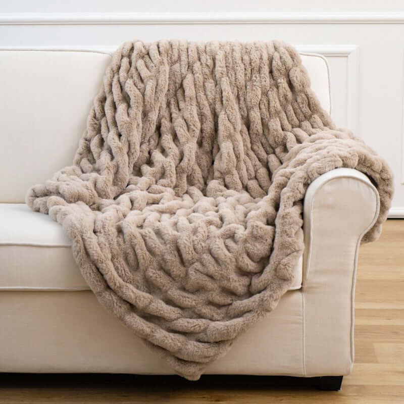 Cozy faux fur pelt blanket draped over a light sofa, adding warmth and style to home decor.