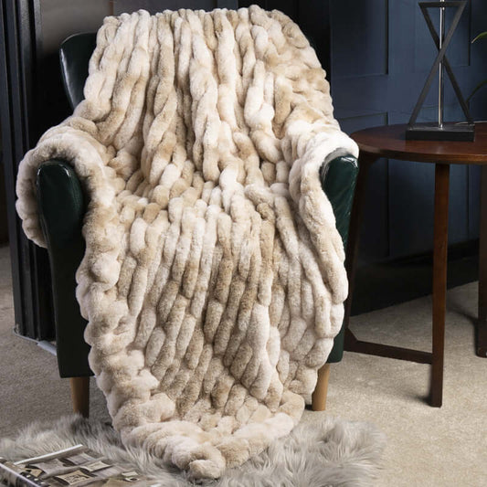 Cozy Faux Fur Pelt Blanket draped over a chair, adding warmth and elegance to stylish home decor.