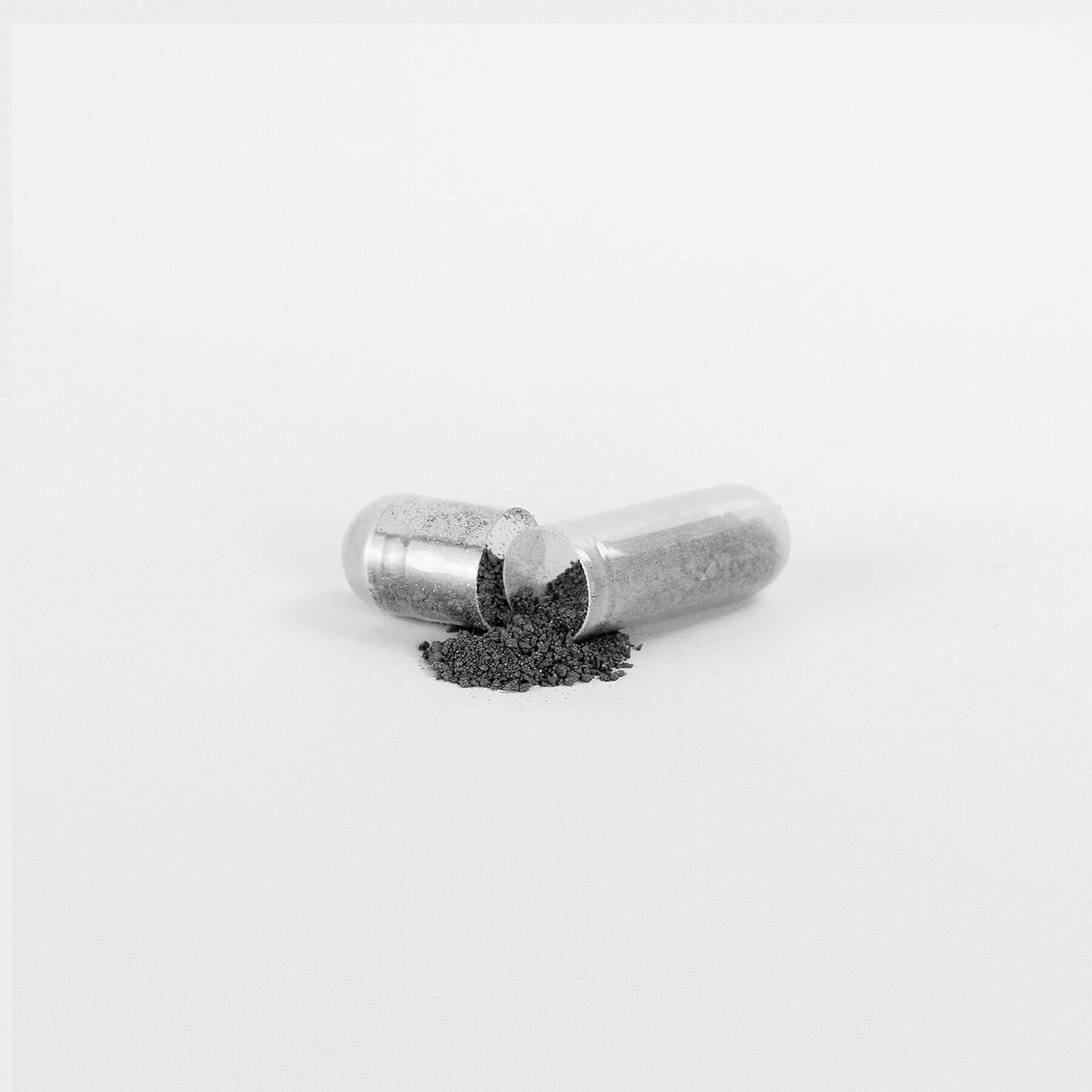 Fulvic Acid Supplement capsule with powder spilling out, enhancing digestive health from natural sources like Birch Chaga, Pine Bark.
