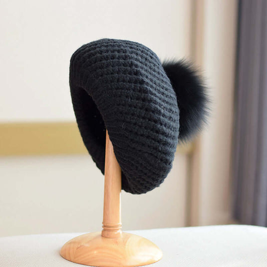 Fur Ball Hat in black, featuring a cozy design and stylish fur pompom, perfect for winter fashion.