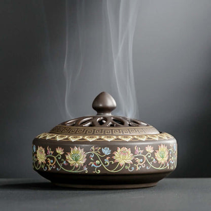 Ceramic incense burner with floral designs releasing aromatic smoke, perfect for tranquility and home decor.