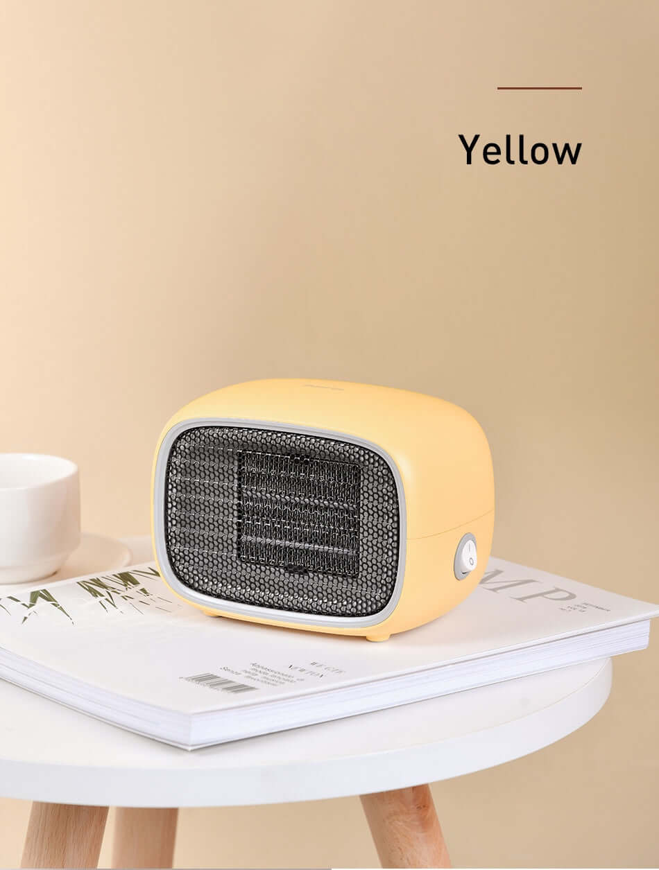 Home Depot Mini Heater in yellow color placed on a table with magazines, showcasing its compact design.