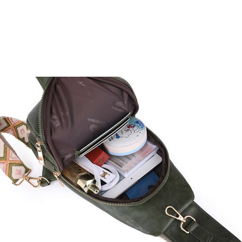 Ladies Cross Shoulder Bag open to show spacious interior with various items. Stylish, durable PU leather bag in elegant dark green.