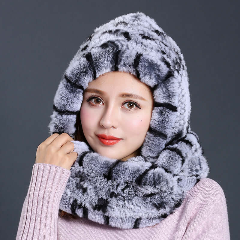 Stylish woman wearing a luxurious faux fur hat with scarf combination in a chic gray design, perfect for winter layering.