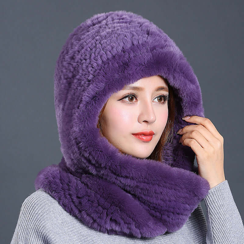 Woman wearing a luxurious purple faux fur hat with scarf, exemplifying warmth and winter style.