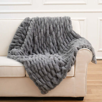 Cozy gray Faux Fur Pelt Blanket draped over a light-colored couch, enhancing home decor with soft texture.