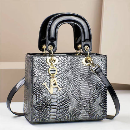 Elegant snakeskin-patterned handbag with black handles and gold accents, designed for modern fashion enthusiasts.
