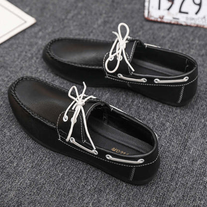 Black faux leather loafers with white laces, offering comfort and style in durable materials. Perfect for everyday wear.