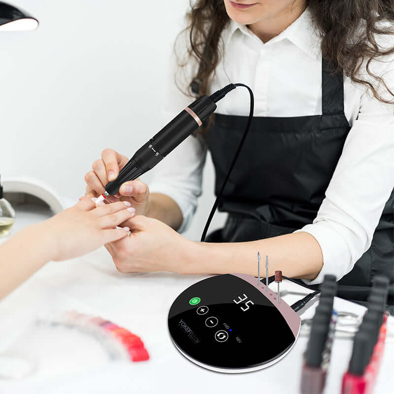 Nail technician using high-speed Nail Drill Machine for precise manicure, featuring robust aluminum and ABS construction.