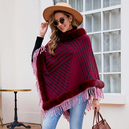 Stylish woman wearing a Poncho Coat with Fur trim, featuring a burgundy color and fringe details, perfect for cozy autumn days.