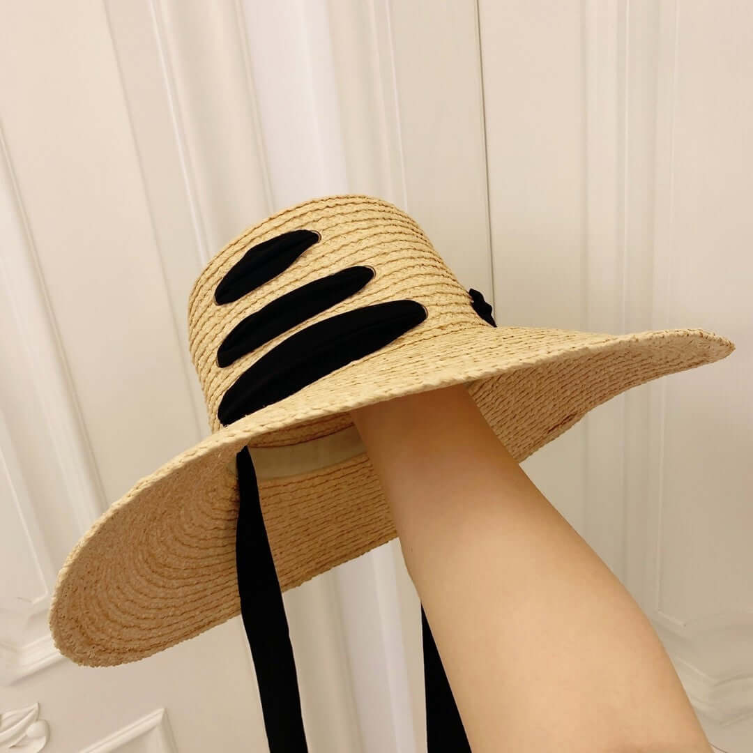 Stylish Raffia Big Brim Hat with black accents for sun protection and summer elegance.