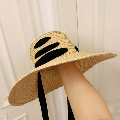 Stylish Raffia Big Brim Hat with black accents for sun protection and summer elegance.