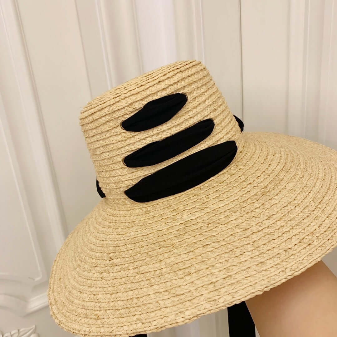 Stylish Raffia Big Brim Hat featuring a chic black accent, perfect for summer outings and sun protection.