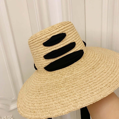 Stylish Raffia Big Brim Hat featuring a chic black accent, perfect for summer outings and sun protection.