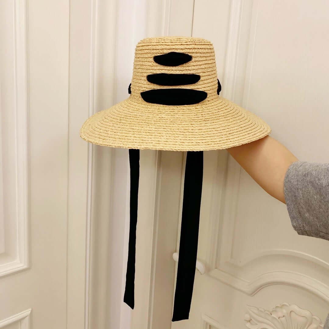 Stylish raffia big brim hat with black detailing, perfect for summer sun protection and outdoor occasions.
