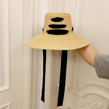 Stylish raffia big brim hat with black detailing, perfect for summer sun protection and outdoor occasions.