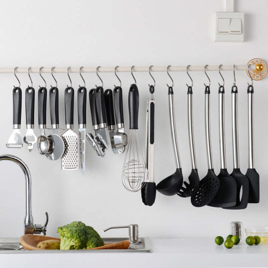 Set of kitchen utensils and tools hanging on a rack, showcasing sleek designs for cooking and baking.