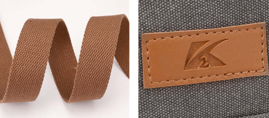 Close-up of Simple Tote Bag's brown canvas strap and leather logo detail on gray fabric, showcasing durability and style.