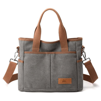 Simple Tote Bag in gray canvas with brown straps, two front pockets, ideal for everyday use. Stylish and functional design.
