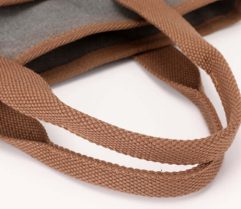 Close-up of brown canvas handles on the Simple Tote Bag, showcasing its durable and lightweight design.