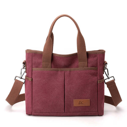 Simple Tote Bag in red canvas with two brown handles and a detachable shoulder strap, ideal for everyday use and available in various colors.