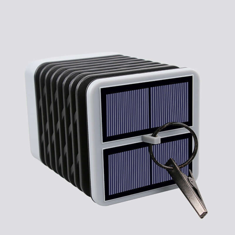 Rectangular solar-powered lantern with key hook for outdoor illumination.
