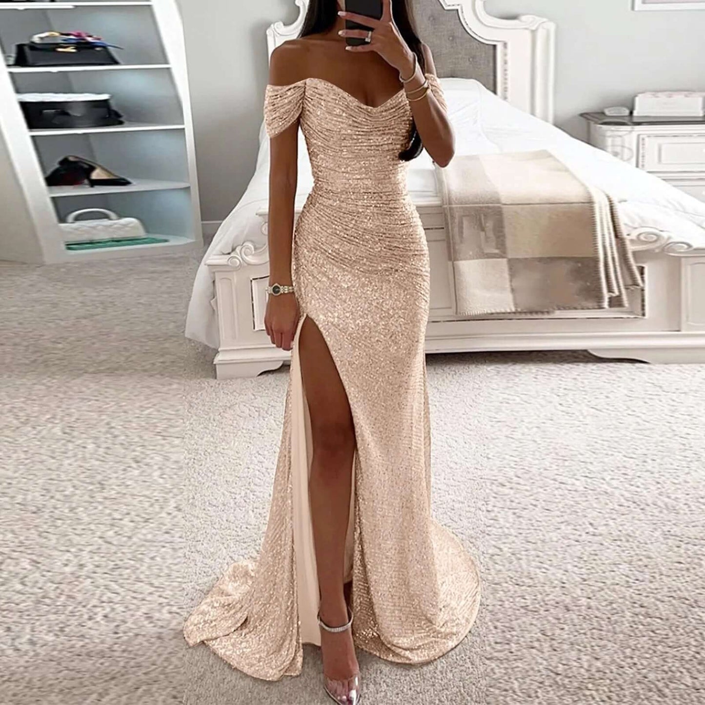 Elegant woman wearing a sparkling slit maxi dress showcasing an off-the-shoulder style and high slit design in an elegant setting.