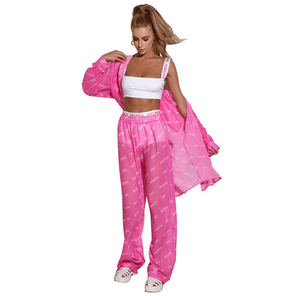 Woman wearing a stylish pink chiffon jumpsuit with unique text design, paired with a white top, showcasing a trendy, flowing fashion look.