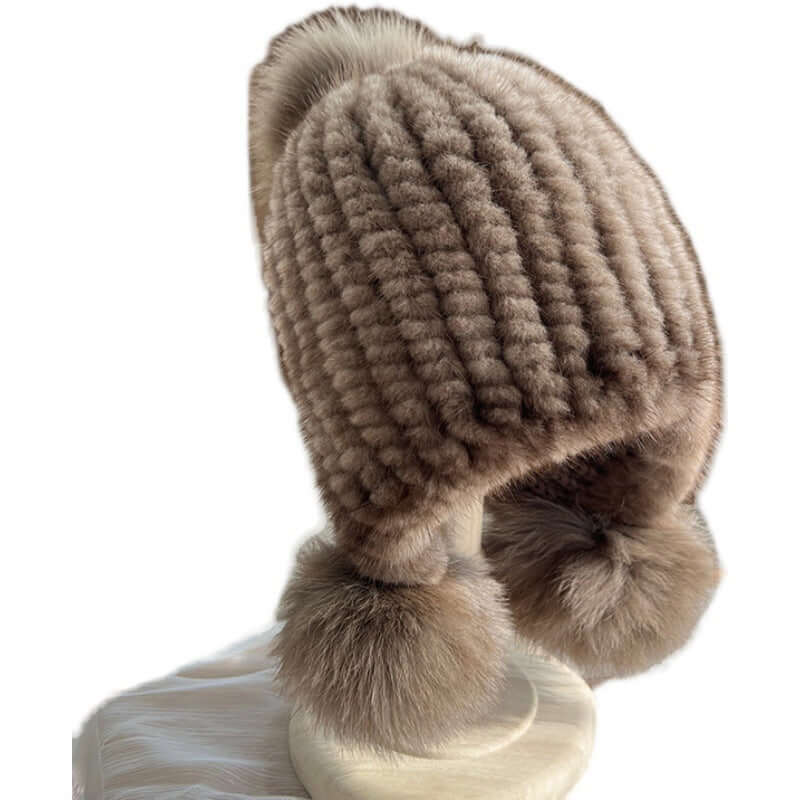 Stylish Ear Muffs Hat featuring a textured design and fluffy pom poms, ideal for keeping warm in winter.