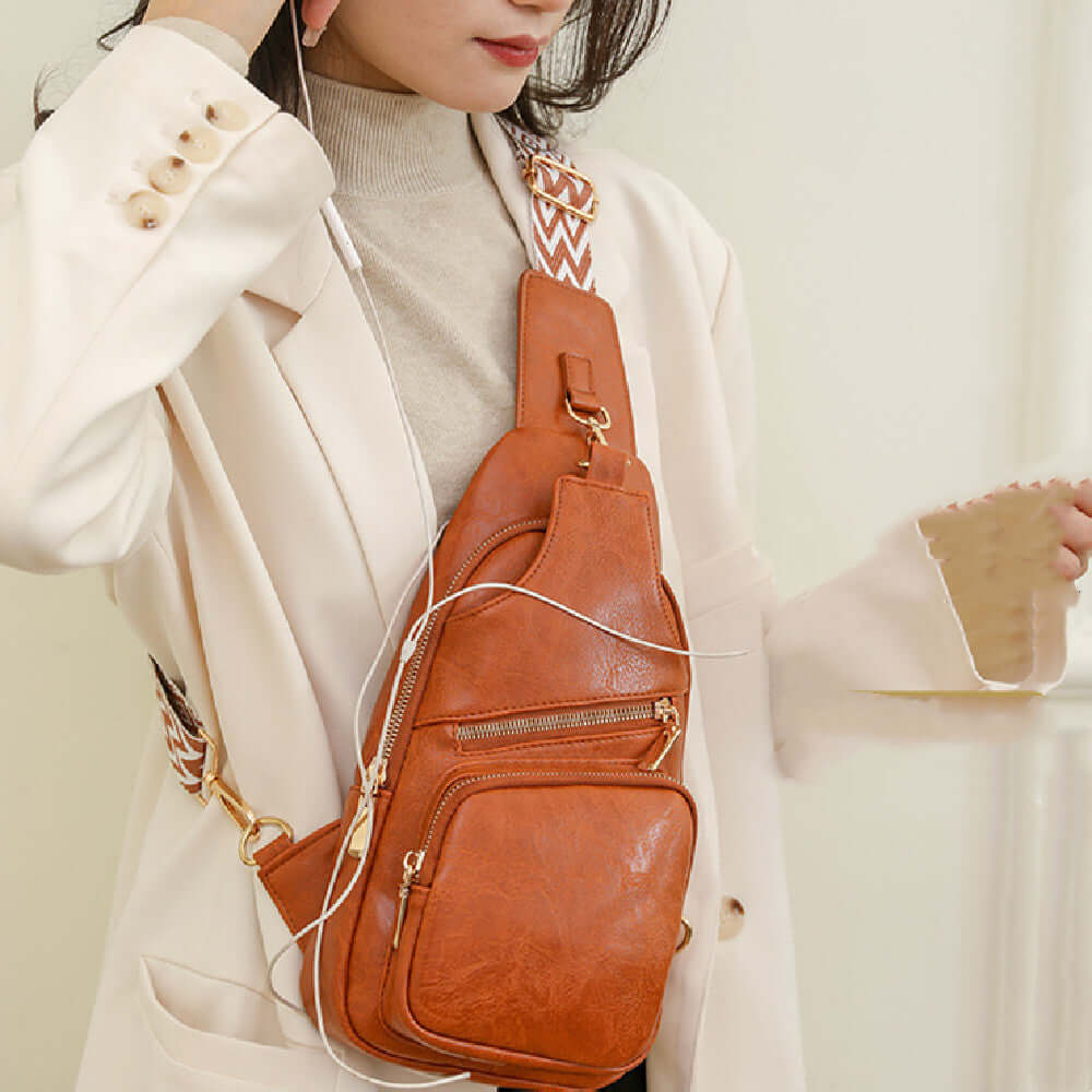 Woman wearing a brown Ladies Cross Shoulder Bag made of PU leather, showcasing its stylish and functional design with multiple pockets.