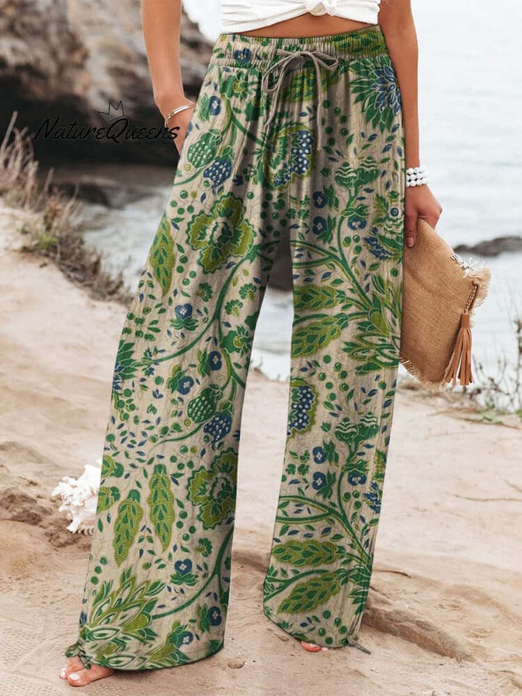 Woman wearing floral wide-leg trousers with green and blue pattern, made from brushed milk silk fabric for comfort and style.