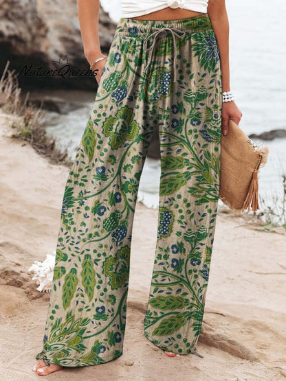Woman wearing floral wide-leg trousers with green and blue pattern, made from brushed milk silk fabric for comfort and style.