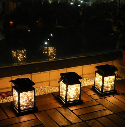 Three wind up lanterns lighting up a wooden deck, ideal for camping or garden retreats with eco-friendly illumination.